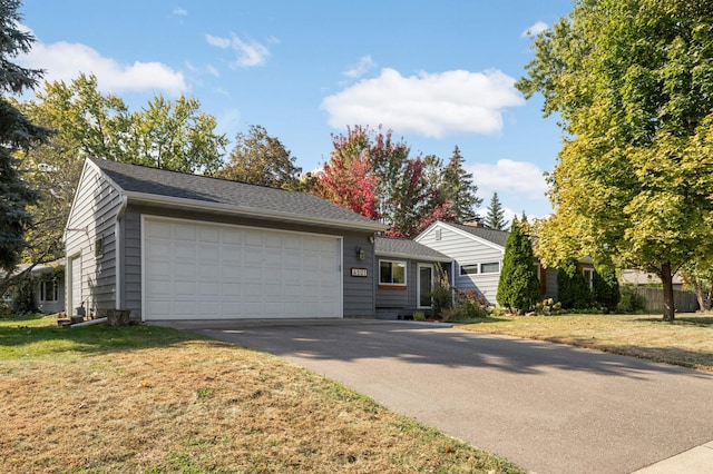 ranch-style home with a garage and a front lawn