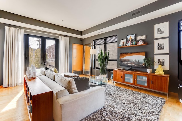 living room featuring visible vents, wood finished floors, and french doors