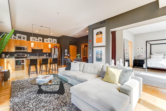 living room with visible vents, recessed lighting, and light wood-style floors