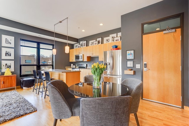 dining room with recessed lighting and light wood-style floors