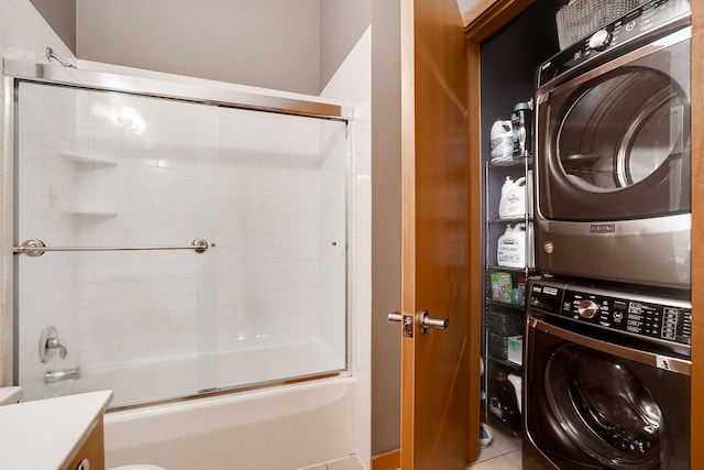 washroom featuring tile patterned flooring, laundry area, and stacked washer / dryer