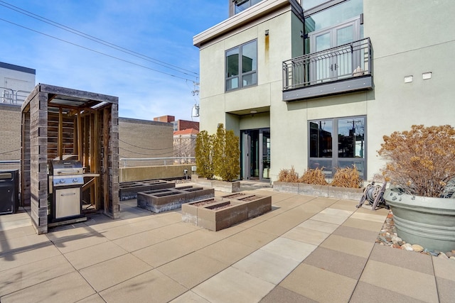 view of patio with a balcony and a vegetable garden