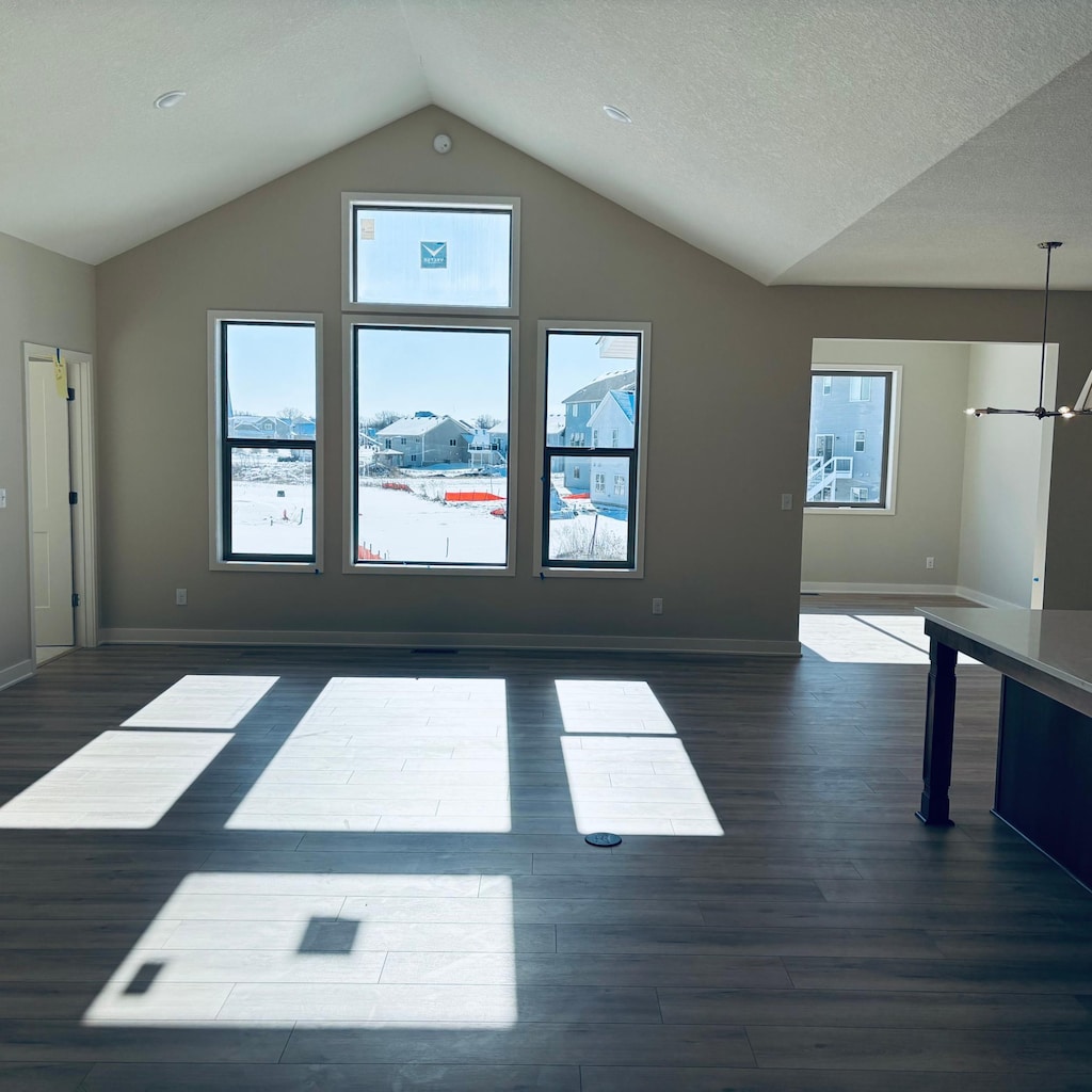 additional living space with vaulted ceiling, dark wood-type flooring, and baseboards