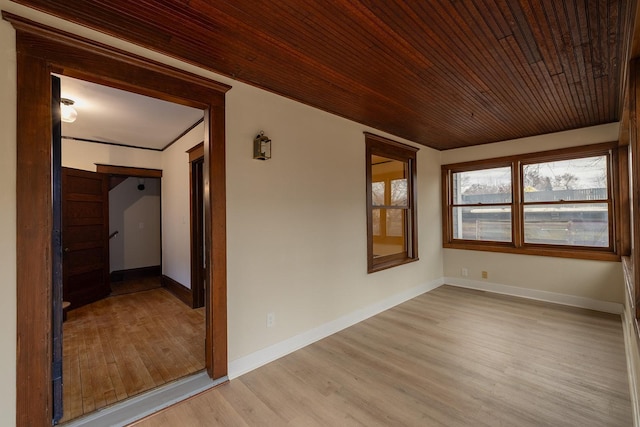 unfurnished room with light wood finished floors, wood ceiling, and baseboards