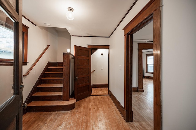 stairs featuring baseboards, crown molding, hardwood / wood-style floors, and decorative columns