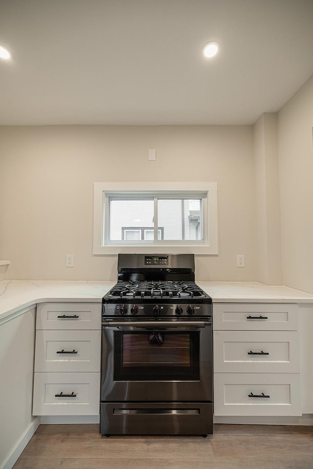 kitchen featuring recessed lighting, white cabinetry, light countertops, light wood-type flooring, and stainless steel gas stove