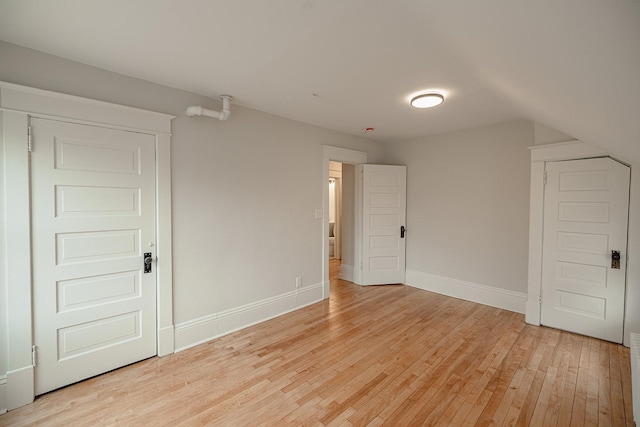 bonus room with lofted ceiling, light wood-type flooring, and baseboards