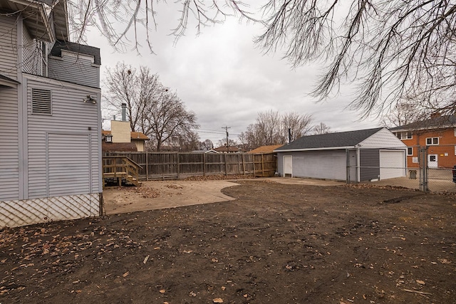 view of yard with a garage, an outdoor structure, and a fenced backyard