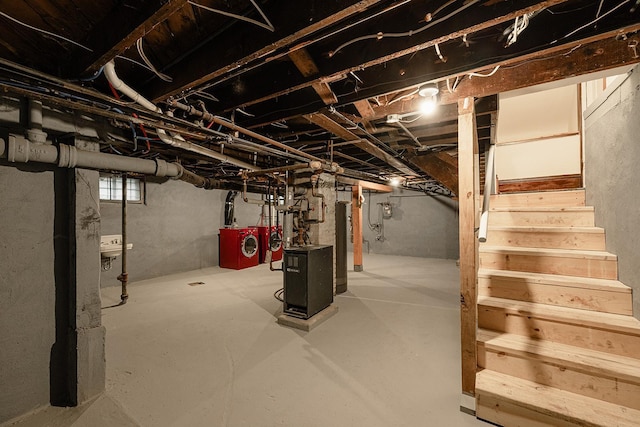 basement featuring water heater, stairway, and washer and dryer