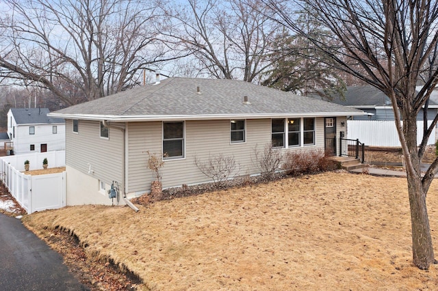 exterior space with roof with shingles and fence