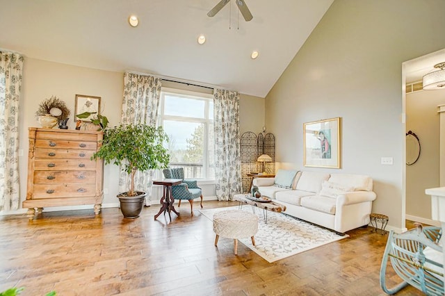 living room featuring baseboards, ceiling fan, wood finished floors, high vaulted ceiling, and recessed lighting