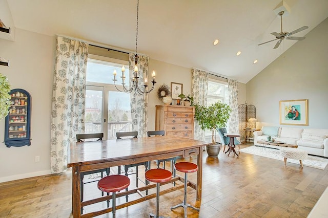 dining space with a wealth of natural light, high vaulted ceiling, and wood finished floors