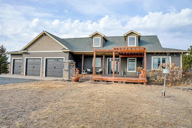 view of front of home with a garage, driveway, a porch, and a shingled roof