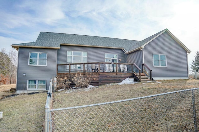 view of front of house featuring a shingled roof, a fenced backyard, and a wooden deck