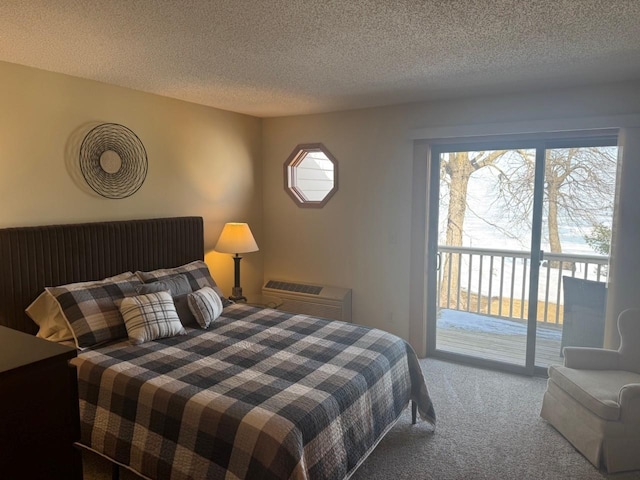 bedroom featuring access to exterior, carpet flooring, and a textured ceiling