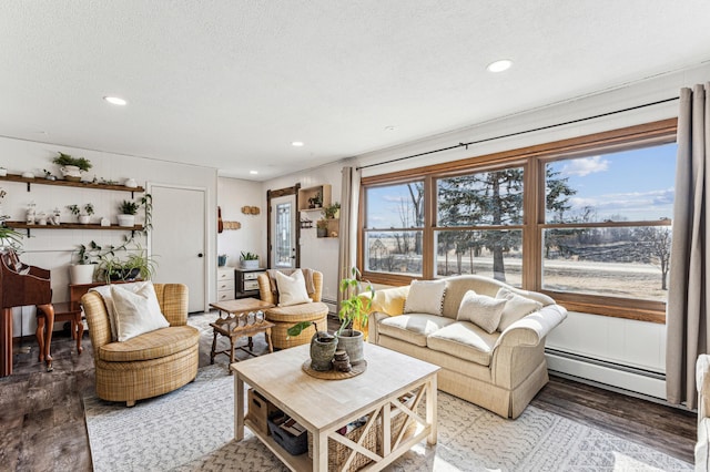 living room featuring light wood-type flooring, a baseboard radiator, a textured ceiling, and recessed lighting