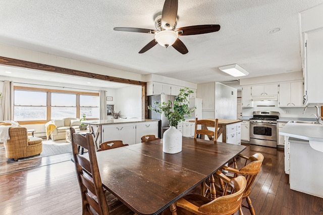 dining space with ceiling fan, a textured ceiling, and dark wood-type flooring