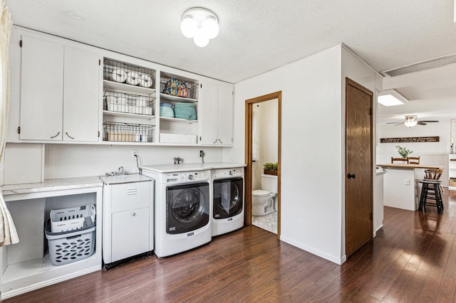 washroom featuring ceiling fan, dark wood-type flooring, cabinet space, and washer and dryer