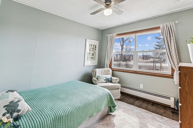 bedroom with a textured ceiling, a ceiling fan, baseboard heating, and wood finished floors