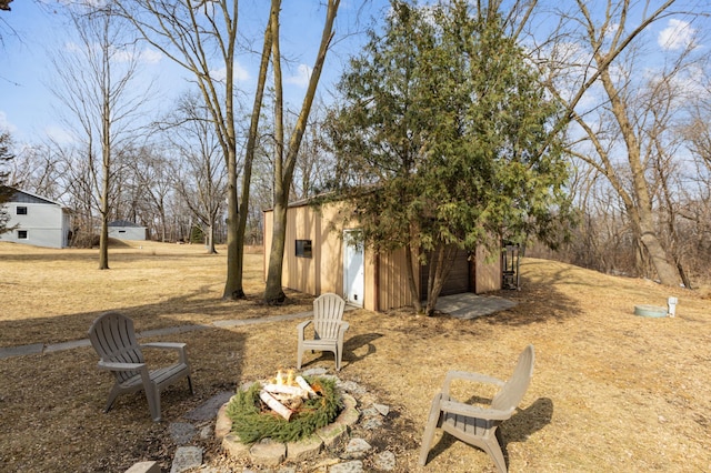 view of yard with an outdoor fire pit and an outdoor structure