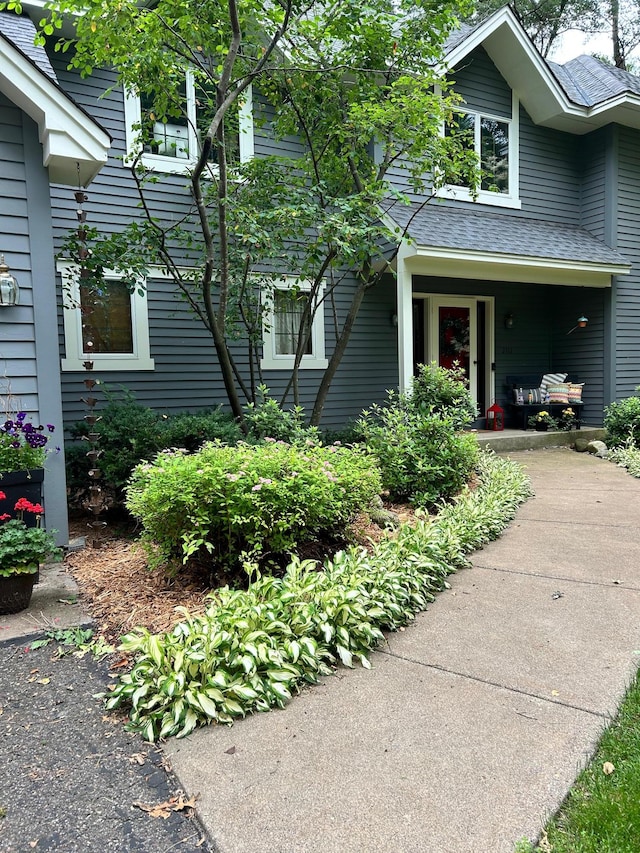 property entrance with a shingled roof