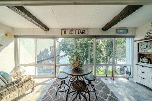 sunroom / solarium featuring beamed ceiling