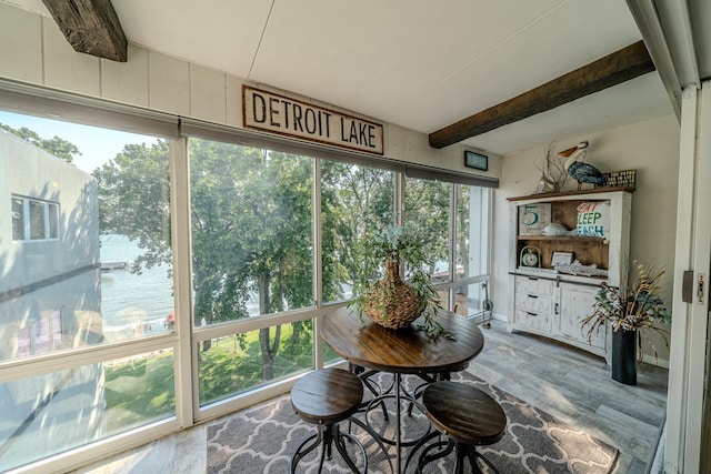 sunroom featuring beam ceiling