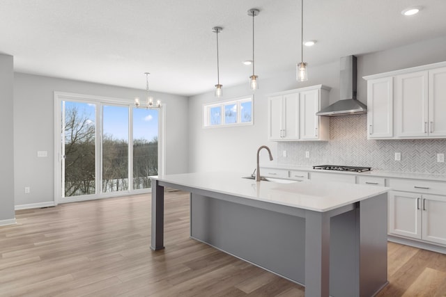 10720 Harbor Ln N, Maple Grove, MN 55369 - kitchen with decorative backsplash, wall chimney exhaust hood, a sink, light countertops, and light wood-style flooring