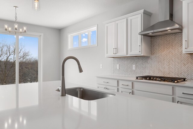 10720 Harbor Ln N, Maple Grove, MN 55369 - kitchen with decorative backsplash, stainless steel gas cooktop, light countertops, wall chimney exhaust hood, and a sink