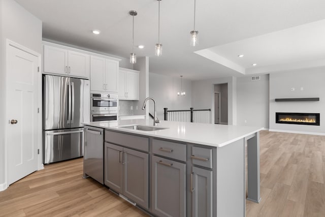 10720 Harbor Ln N, Maple Grove, MN 55369 - kitchen featuring a sink, light wood-style floors, gray cabinets, stainless steel appliances, and recessed lighting