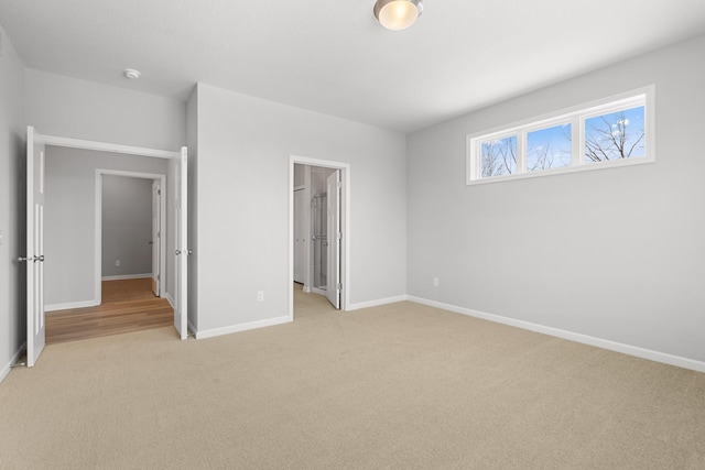 10720 Harbor Ln N, Maple Grove, MN 55369 - unfurnished bedroom featuring baseboards, light carpet, and a walk in closet