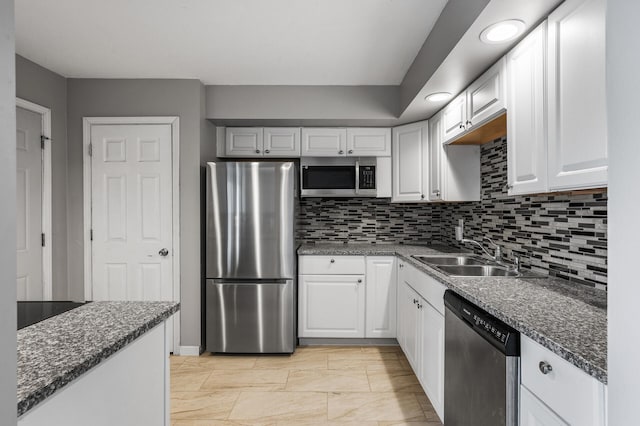 kitchen featuring stainless steel appliances, a sink, and white cabinets