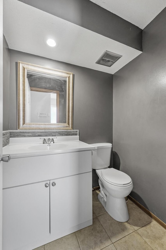 bathroom with baseboards, visible vents, toilet, tile patterned floors, and vanity