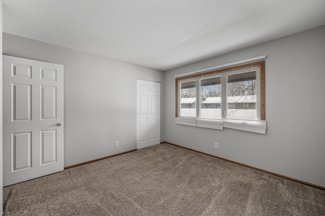 carpeted empty room with baseboards