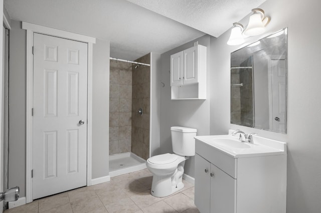 full bath with toilet, vanity, a textured ceiling, tile patterned flooring, and tiled shower