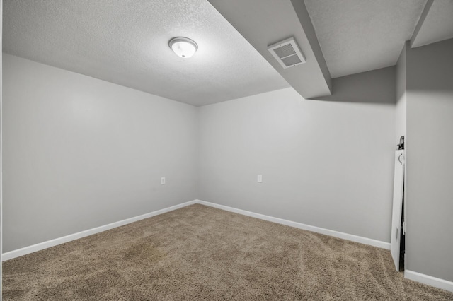 unfurnished room featuring carpet floors, visible vents, a textured ceiling, and baseboards