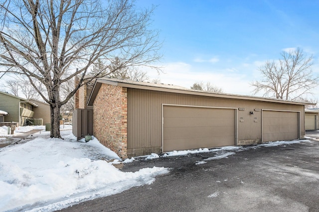 snow covered garage featuring a garage