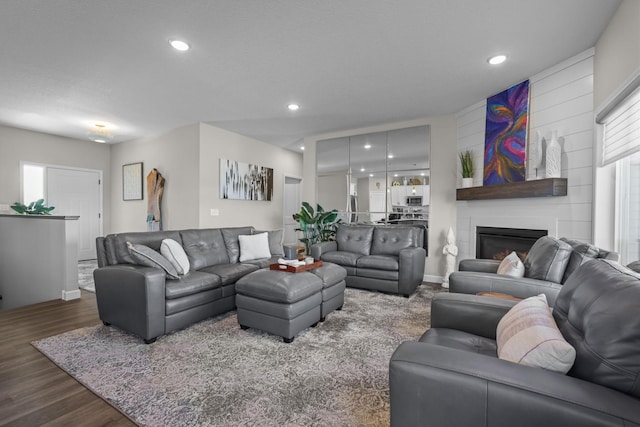 living room featuring recessed lighting, a fireplace, and wood finished floors