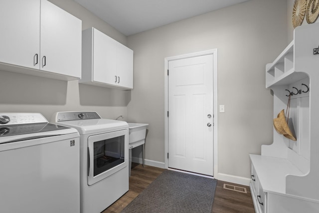 laundry room featuring cabinet space, baseboards, dark wood-type flooring, and washing machine and clothes dryer