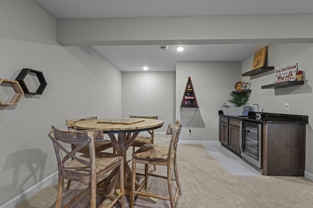 dining room with wet bar, light colored carpet, baseboards, and wine cooler