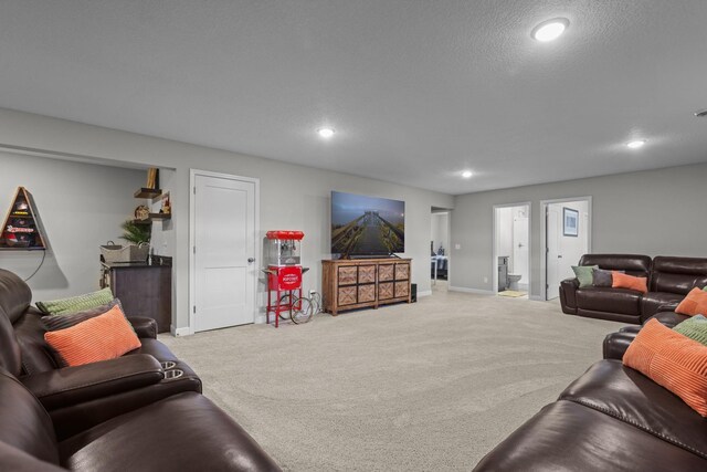 carpeted living area with recessed lighting, a textured ceiling, and baseboards