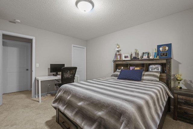 bedroom with a textured ceiling and light colored carpet