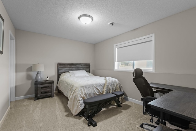 carpeted bedroom with a textured ceiling and baseboards