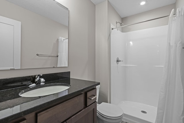 full bath with a stall shower, vanity, and toilet