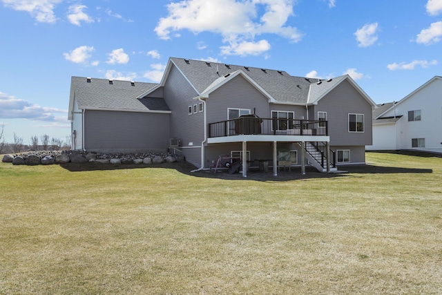 rear view of house with a deck, a yard, stairway, and a shingled roof