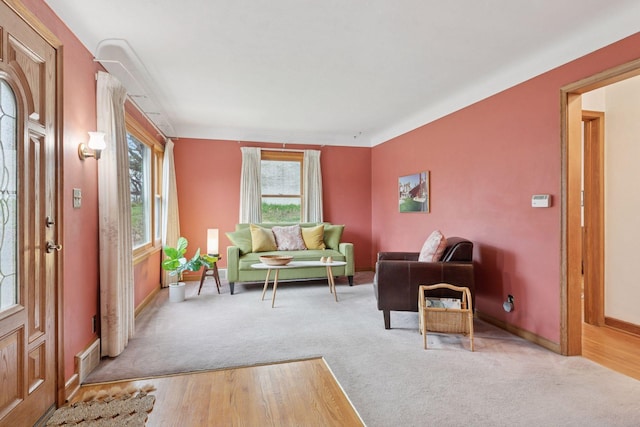 living area featuring plenty of natural light, carpet flooring, and baseboards