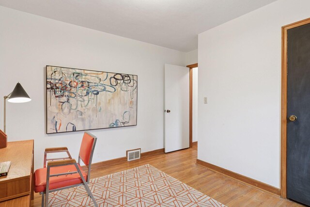 office area with baseboards, visible vents, and light wood finished floors