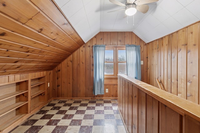 bonus room featuring vaulted ceiling, wood walls, ceiling fan, and dark floors
