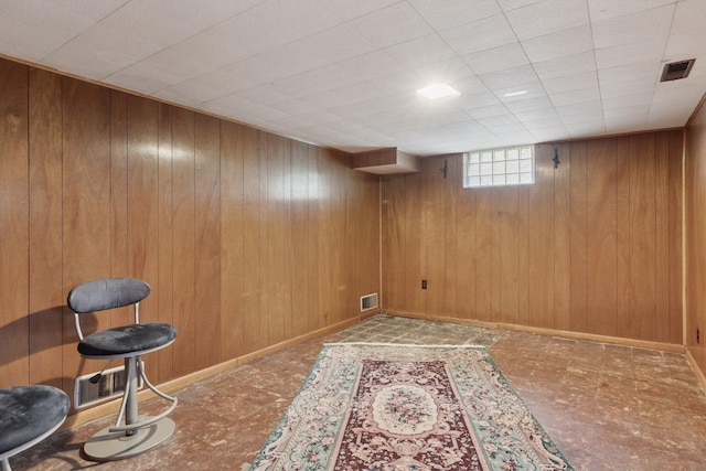 basement featuring wooden walls and visible vents
