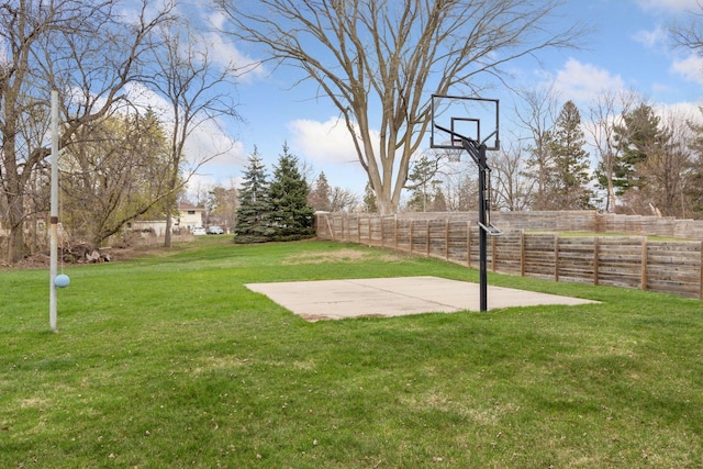view of yard featuring fence and basketball court